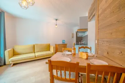a living room with a table and a yellow couch at Chamonix Sud - Bâtiment C 121 - Happy Rentals in Chamonix-Mont-Blanc