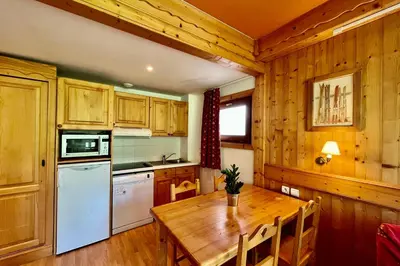 a kitchen with a wooden table and a white refrigerator at Second de Cordée in Combloux