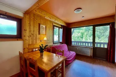 a dining room with a table and a purple couch at Second de Cordée in Combloux