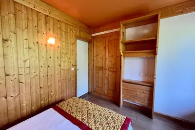 a bedroom with wooden walls and a bed in a room at Second de Cordée in Combloux