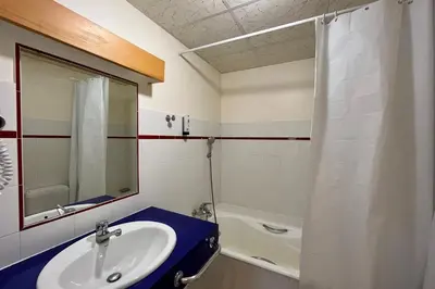 a bathroom with a sink and a mirror and a tub at Second de Cordée in Combloux