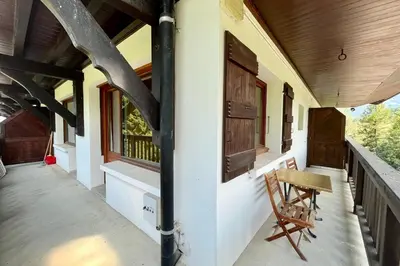 a porch of a house with a table and a chair at Second de Cordée in Combloux