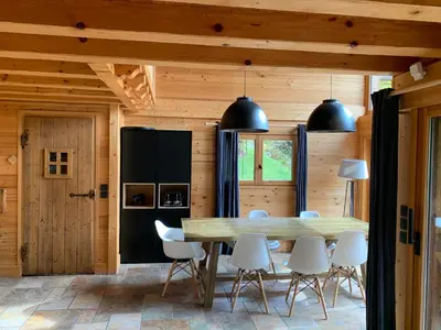 a dining room with a table and white chairs at Superbe CHALET (14 personnes) & SAUNA au pied du Mont Blanc in Les Contamines-Montjoie
