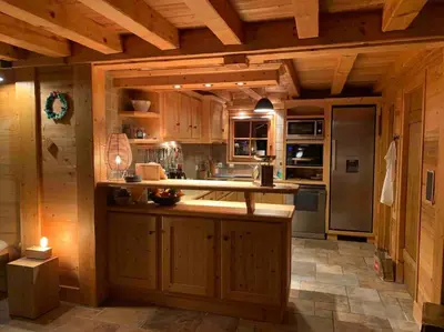 a large kitchen with wooden cabinets and a counter top at Superbe CHALET (14 personnes) & SAUNA au pied du Mont Blanc in Les Contamines-Montjoie