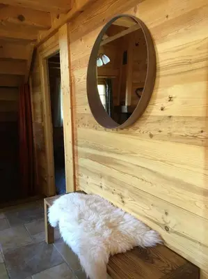 a mirror on the wall of a cabin with a white rug at Superbe CHALET (14 personnes) & SAUNA au pied du Mont Blanc in Les Contamines-Montjoie