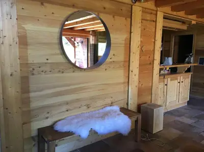 a log cabin with a mirror and a bench at Superbe CHALET (14 personnes) & SAUNA au pied du Mont Blanc in Les Contamines-Montjoie