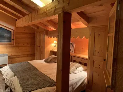 a bedroom with a bed in a log cabin at Superbe CHALET (14 personnes) & SAUNA au pied du Mont Blanc in Les Contamines-Montjoie