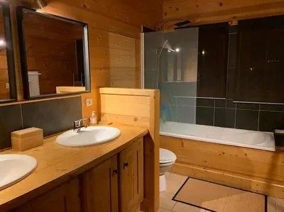 a bathroom with two sinks and a toilet and a tub at Superbe CHALET (14 personnes) & SAUNA au pied du Mont Blanc in Les Contamines-Montjoie