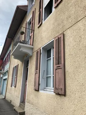 a building with shuttered windows and a balcony at Le Mont Joly & Les 4 Têtes in Sallanches