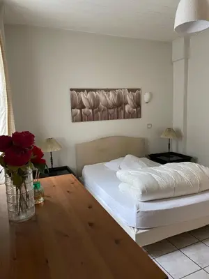 a bedroom with a white bed and a vase of roses at Le Mont Joly & Les 4 Têtes in Sallanches
