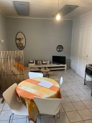 a dining room with a table and white chairs at Le Mont Joly & Les 4 Têtes in Sallanches