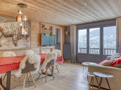 a living room with a table and chairs and a television at Appartement 3 pièces à Megève, balcon sud-est, TV et garage ski - FR-1-453-308 in Megève