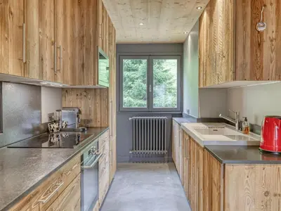 a large kitchen with wooden cabinets and a window at Appartement 3 pièces à Megève, balcon sud-est, TV et garage ski - FR-1-453-308 in Megève