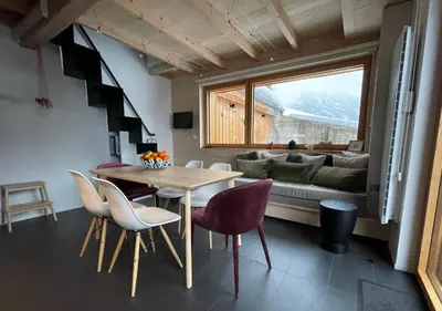 a room with a table and chairs and a couch at Chalet*** au pied d'une prairie face à la montagne in Sixt