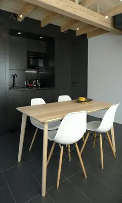 a wooden table with white chairs in a kitchen at Chalet*** au pied d'une prairie face à la montagne in Sixt