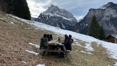 a group of people sitting at a table on a mountain at Chalet*** au pied d'une prairie face à la montagne in Sixt