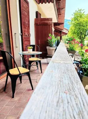 a porch with a table and chairs and a table at les loges de l'Arpenaz in Magland