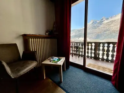 a room with a chair and a table and a window at les loges de l'Arpenaz in Magland