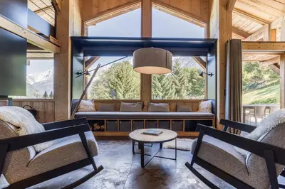 a living room with a large window and a couch at Chalet Castor in Les Houches