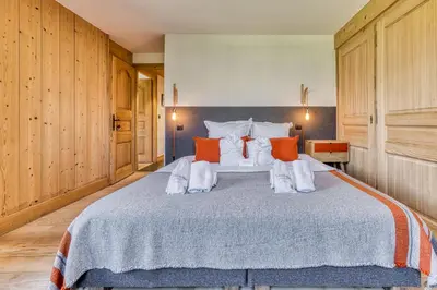 a bedroom with a large bed with orange and white pillows at Chalet Castor in Les Houches