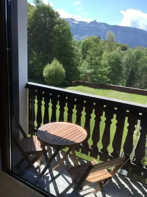 a wooden chair sitting on a balcony with a view at Studio très lumineux 4 pers in Les Carroz d'Araches