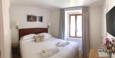 a bedroom with a white bed with towels on it at Chalet Oryx in Chamonix-Mont-Blanc