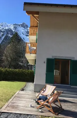 a chair sitting on a deck in front of a house at Chalet Oryx in Chamonix-Mont-Blanc