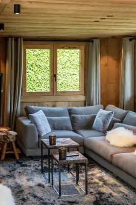 a living room with a couch and a table at Megève - Chalet Miage in Demi-Quartier
