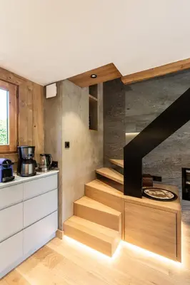 a kitchen with wooden stairs in a room at Megève - Chalet Miage in Demi-Quartier
