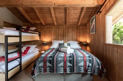 a bedroom with two bunk beds and a window at Megève - Chalet Miage in Demi-Quartier