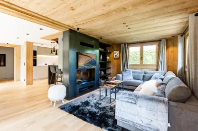 a living room with a couch and a fireplace at Megève - Chalet Miage in Demi-Quartier