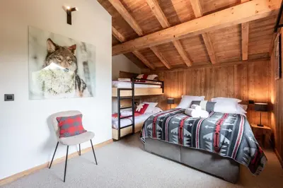 a bedroom with a wolf picture on the wall at Megève - Chalet Miage in Demi-Quartier