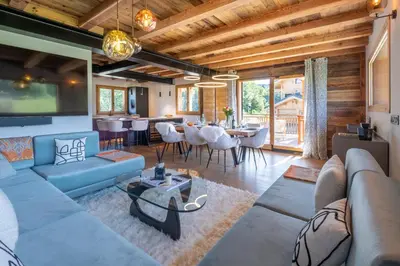 a living room with a couch and a table at Chalet Ango I Jacuzzi & Hammam I Proche télécabine in Combloux