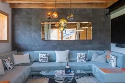 a living room with a blue couch and a table at Chalet Ango I Jacuzzi & Hammam I Proche télécabine in Combloux