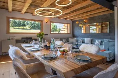 a dining room with a table and a couch at Chalet Ango I Jacuzzi & Hammam I Proche télécabine in Combloux