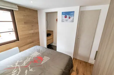 a small bedroom with a bed and a window at Megeve centre ville in Megève