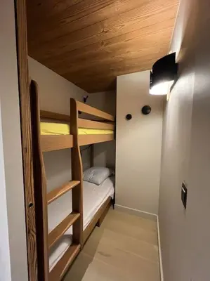 a bedroom with a large bed and a mirror at Appartement chaleureux Megève in Demi-Quartier