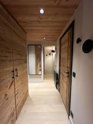 a large wooden door in a room with a bedroom at Appartement chaleureux Megève in Demi-Quartier
