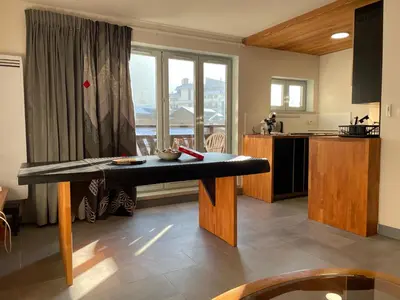 a kitchen with a bench in the middle of a room at Lyret - Centre ville, vue MontBlanc, parking, wifi in Chamonix-Mont-Blanc