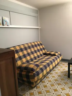 a couch sitting in a living room with at Lyret - Centre ville, vue MontBlanc, parking, wifi in Chamonix-Mont-Blanc