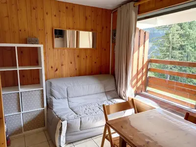 a room with a couch and a table and a window at Studio confortable · 4 personnes · Flaine Centre · Terrasse - FR-1-425-204 in Arâches-la-Frasse