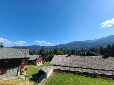 a group of buildings with mountains in the background at Appartement 3 pièces cosy, 6 personnes, près de la piscine et du ski bus, parking inclus. - FR-1-572-285 in Arâches-la-Frasse