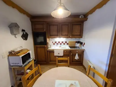 a kitchen with a table and a microwave at Appartement 3 pièces cosy, 6 personnes, près de la piscine et du ski bus, parking inclus. - FR-1-572-285 in Arâches-la-Frasse