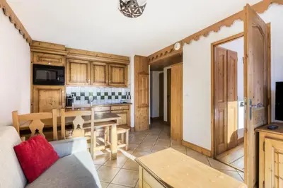 a kitchen and living room with a table and a couch at Résidence Les Fermes du Soleil - maeva Home - Appartement 3 Pièces 6 Personnes - Sélection MAE-6505 in Les Carroz d'Araches