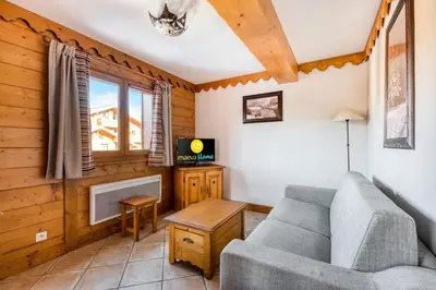 a living room with a couch and a tv at Résidence Les Fermes du Soleil - maeva Home - Appartement 3 pièces 6 Personnes - Sélection MAE-1535 in Les Carroz d'Araches