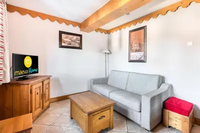 a living room with a couch and a tv at Résidence Les Fermes du Soleil - maeva Home - Appartement 3 pièces 6 Personnes - Sélection MAE-1535 in Les Carroz d'Araches