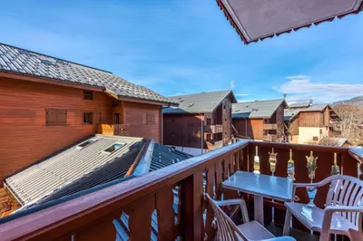 a deck with a table and chairs on a balcony at Résidence Les Fermes du Soleil - maeva Home - Appartement 3 pièces 6 Personnes - Sélection MAE-1535 in Les Carroz d'Araches