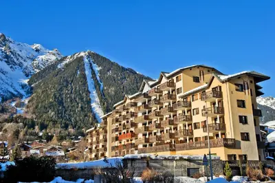 a large building in front of a mountain at Résidence La Rivière - maeva Home - Appartement 2 pièces 6 personnes - Sélection MAE-8671 in Chamonix-Mont-Blanc