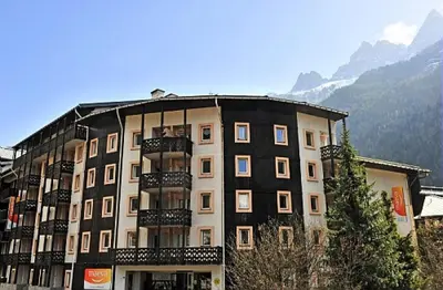 a large building with balconies in front of a mountain at Résidence La Rivière - maeva Home - Appartement 2 pièces 6 personnes - Sélection MAE-8671 in Chamonix-Mont-Blanc