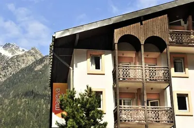 a building with balconies on the side of it with mountains at Résidence La Rivière - maeva Home - Appartement 2 pièces 6 personnes - Sélection MAE-8671 in Chamonix-Mont-Blanc